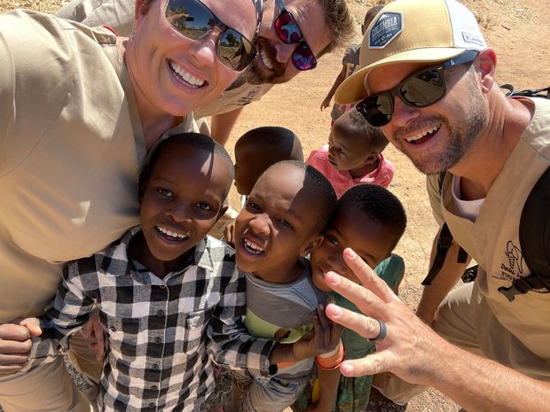 A group of people are posing for a picture with a group of children.