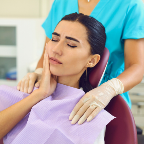 A woman in a dental chair has a toothache