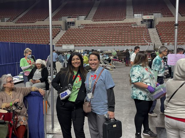 Two women are posing for a picture in an empty stadium.