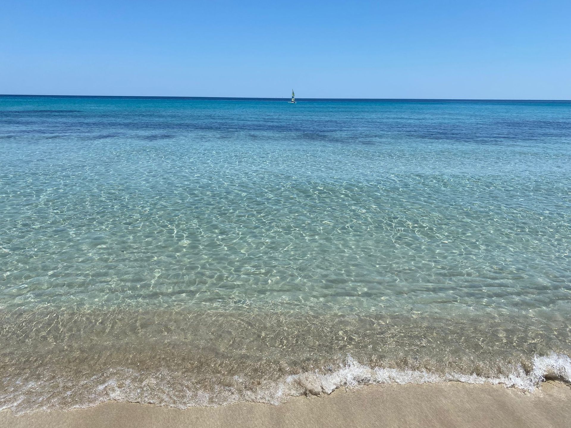 Due sedie a sdraio sull'erba verde si affacciano sull'oceano al tramonto.