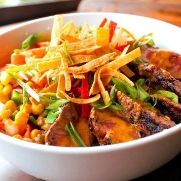 Southwestern Steak Bowl $18
Prime NY Strip, Farro, Avocado, Tomatoes, Black Bean Corn Salsa, Mojo Dressing, Tortilla Strips, Chives, Lime