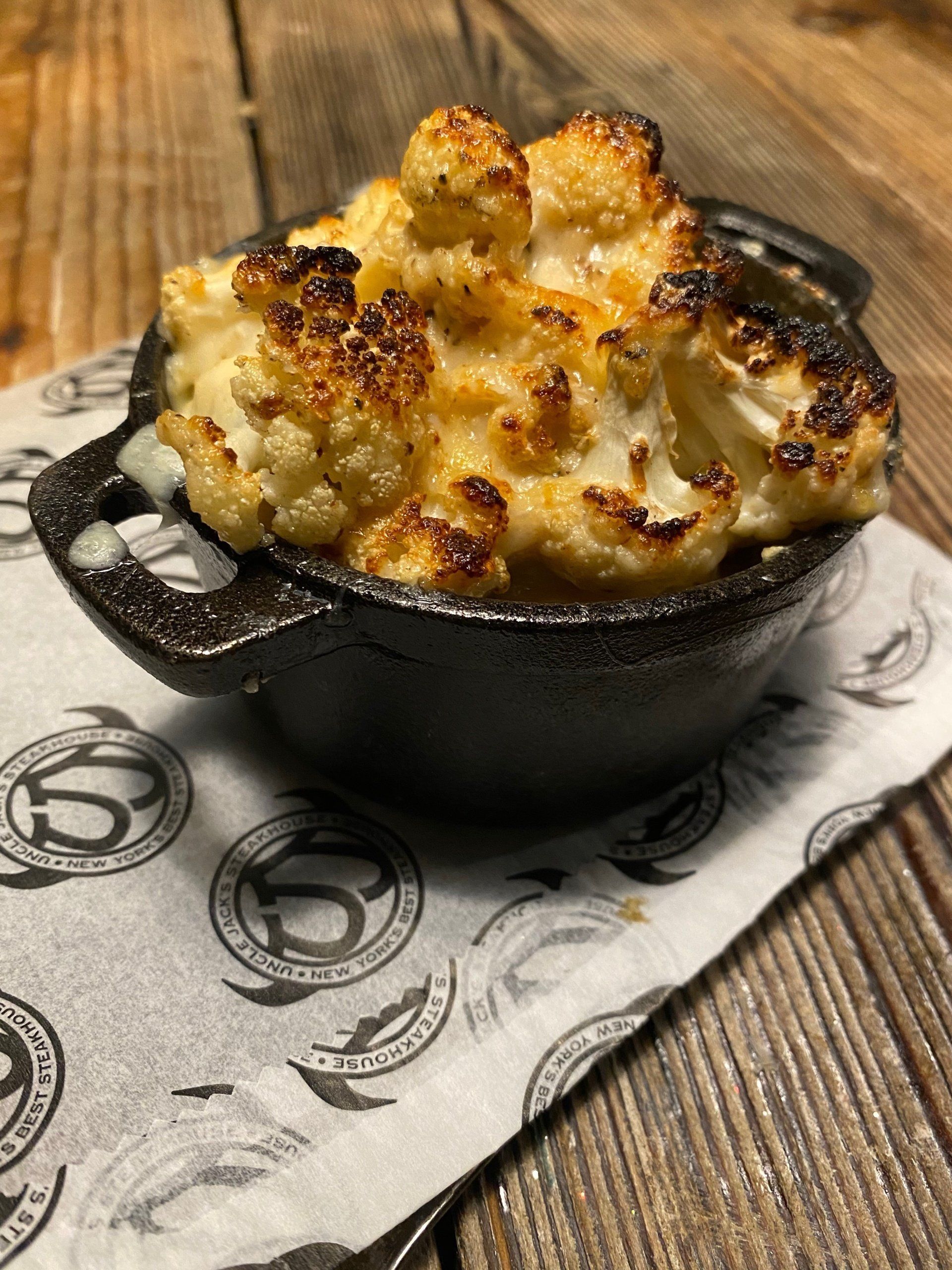 a bowl of cauliflower is on a napkin that says steakhouse