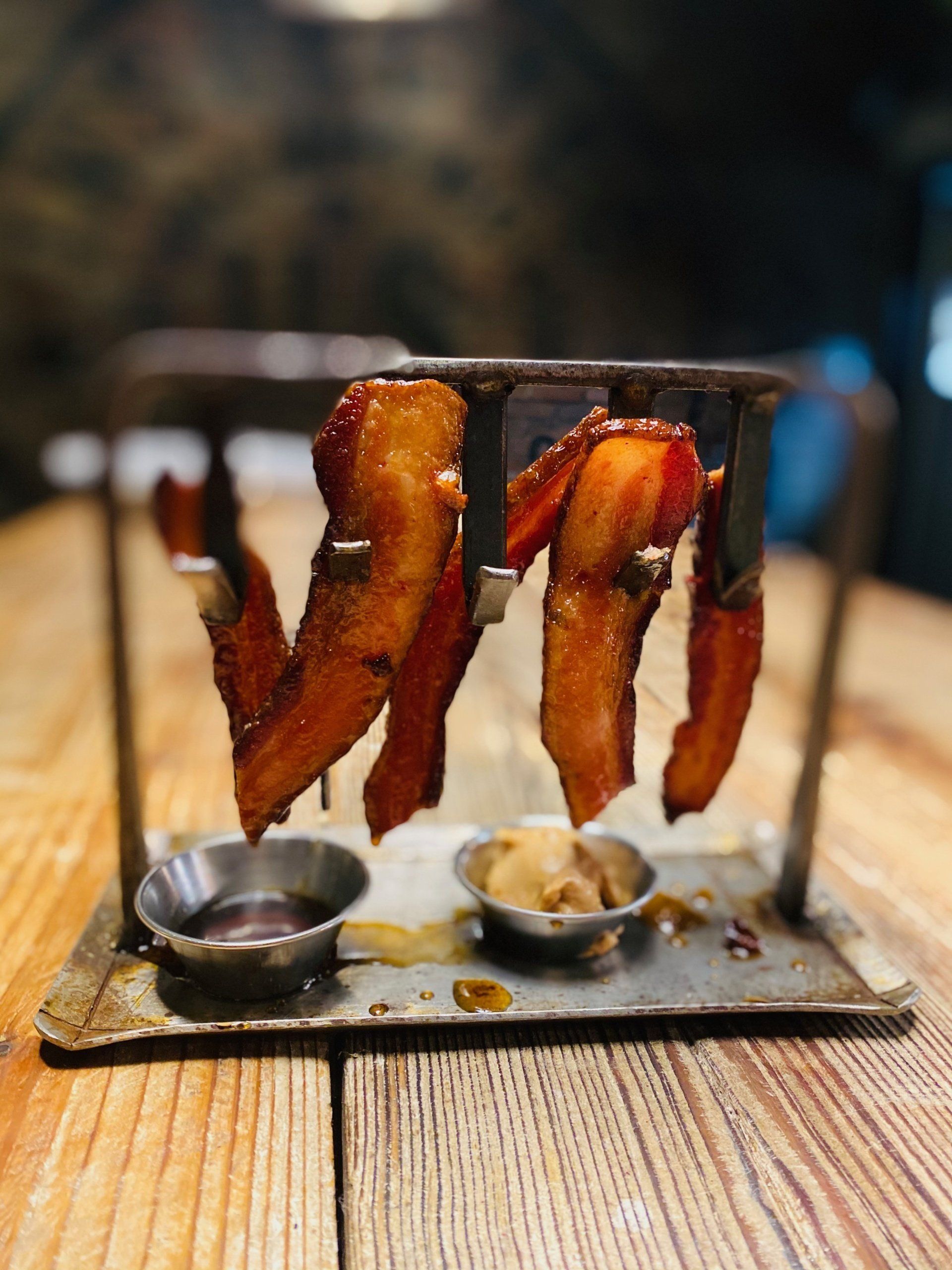 three pieces of bacon are hanging from a metal rack