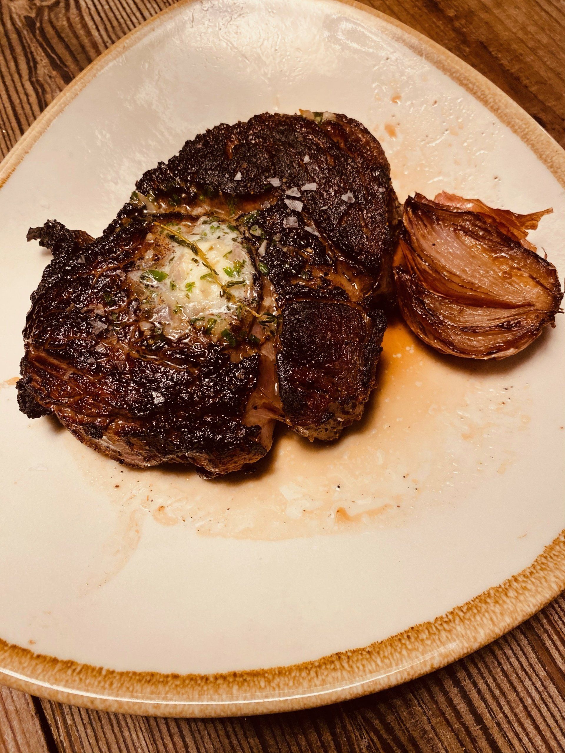 a white plate topped with a steak and onions