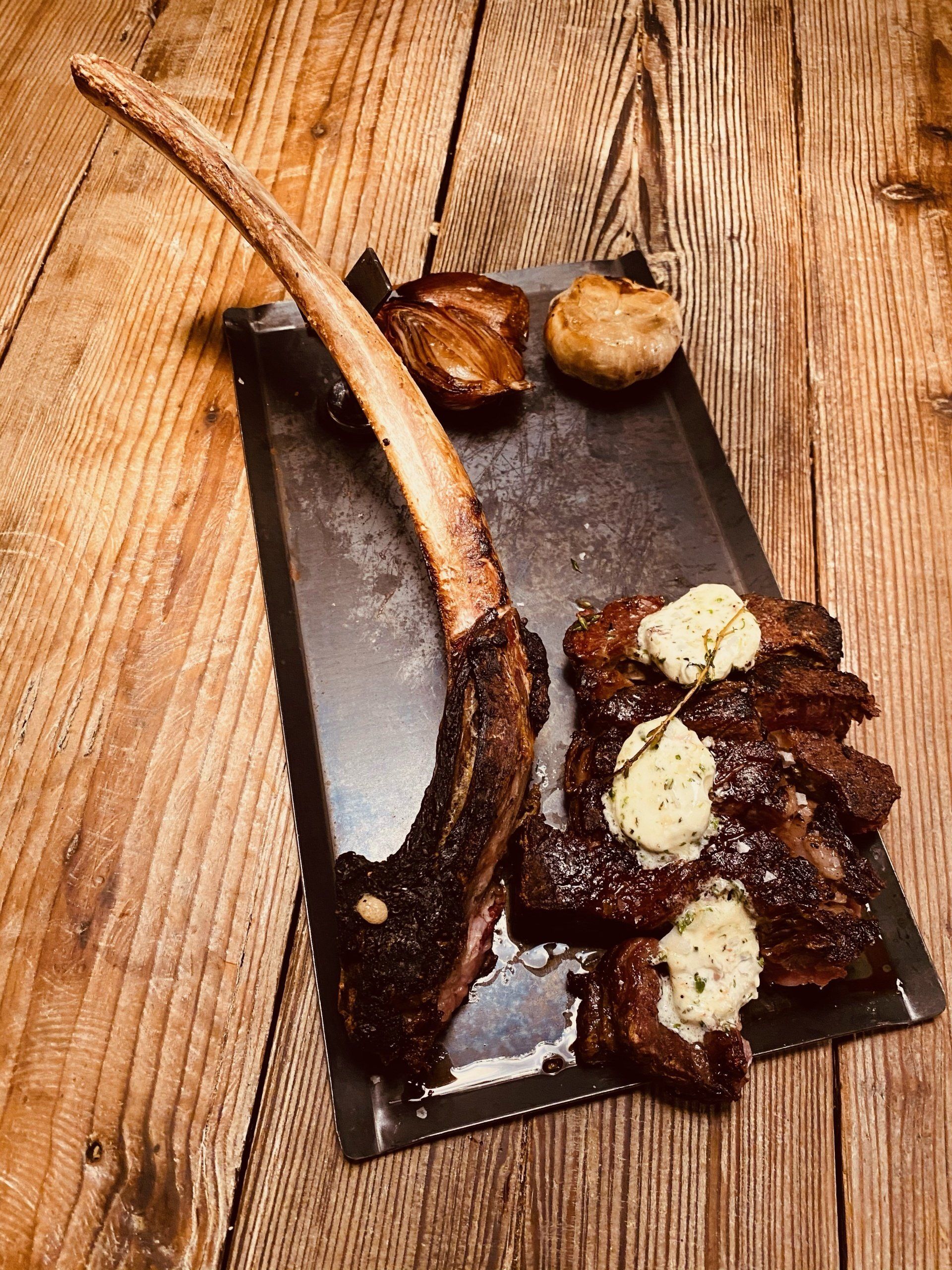 a steak on a cutting board with butter on it