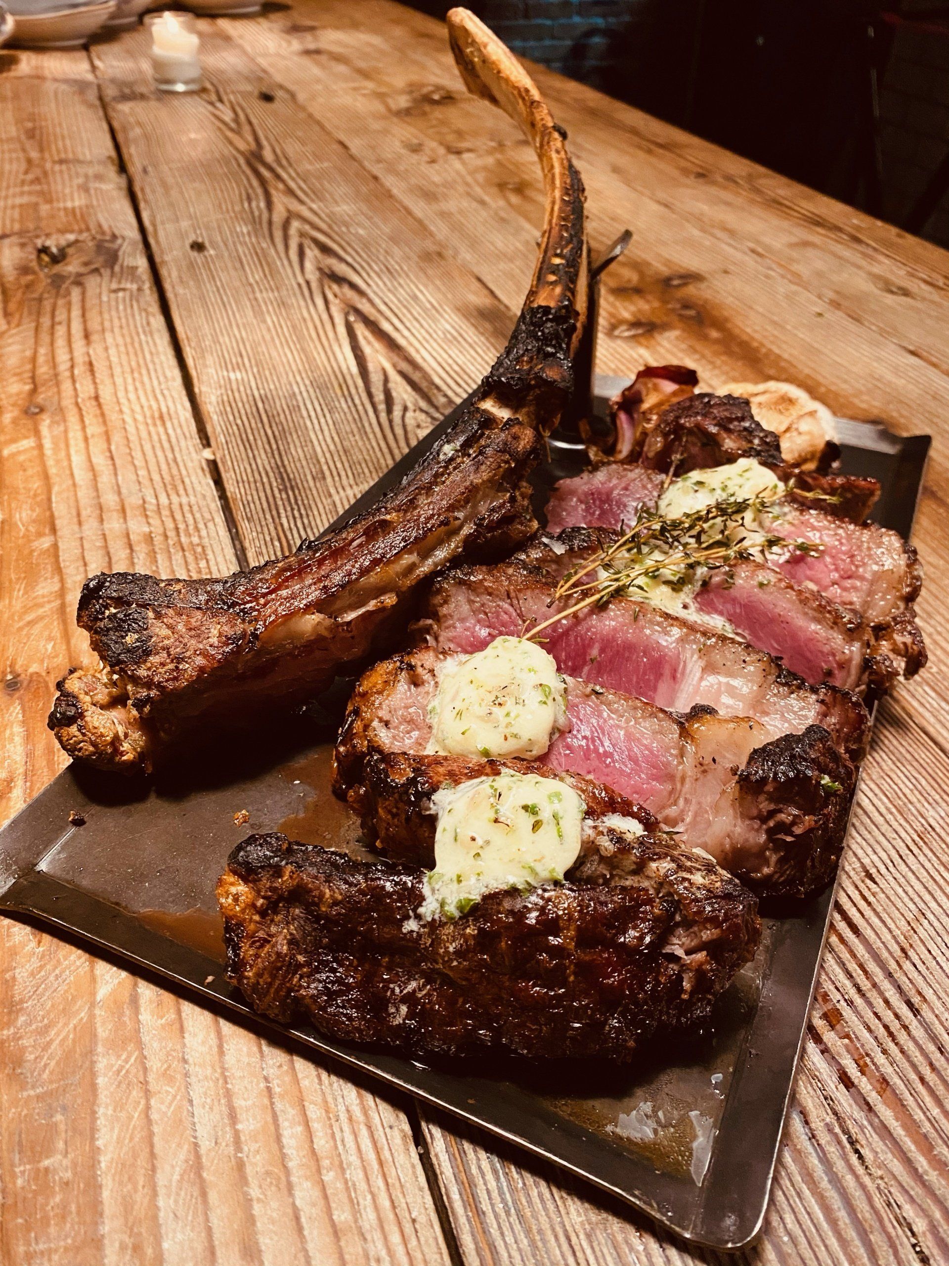a large piece of meat is on a metal tray on a wooden table