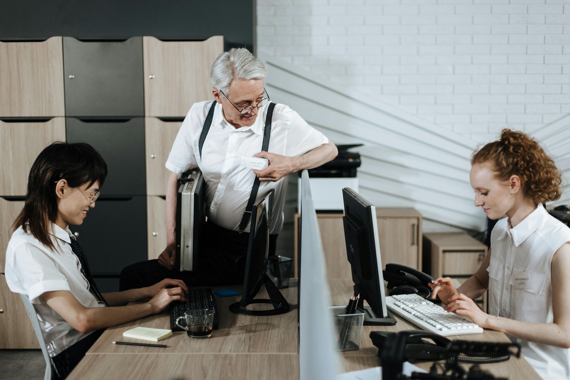 Un grupo de personas está sentada en un escritorio frente a una computadora.