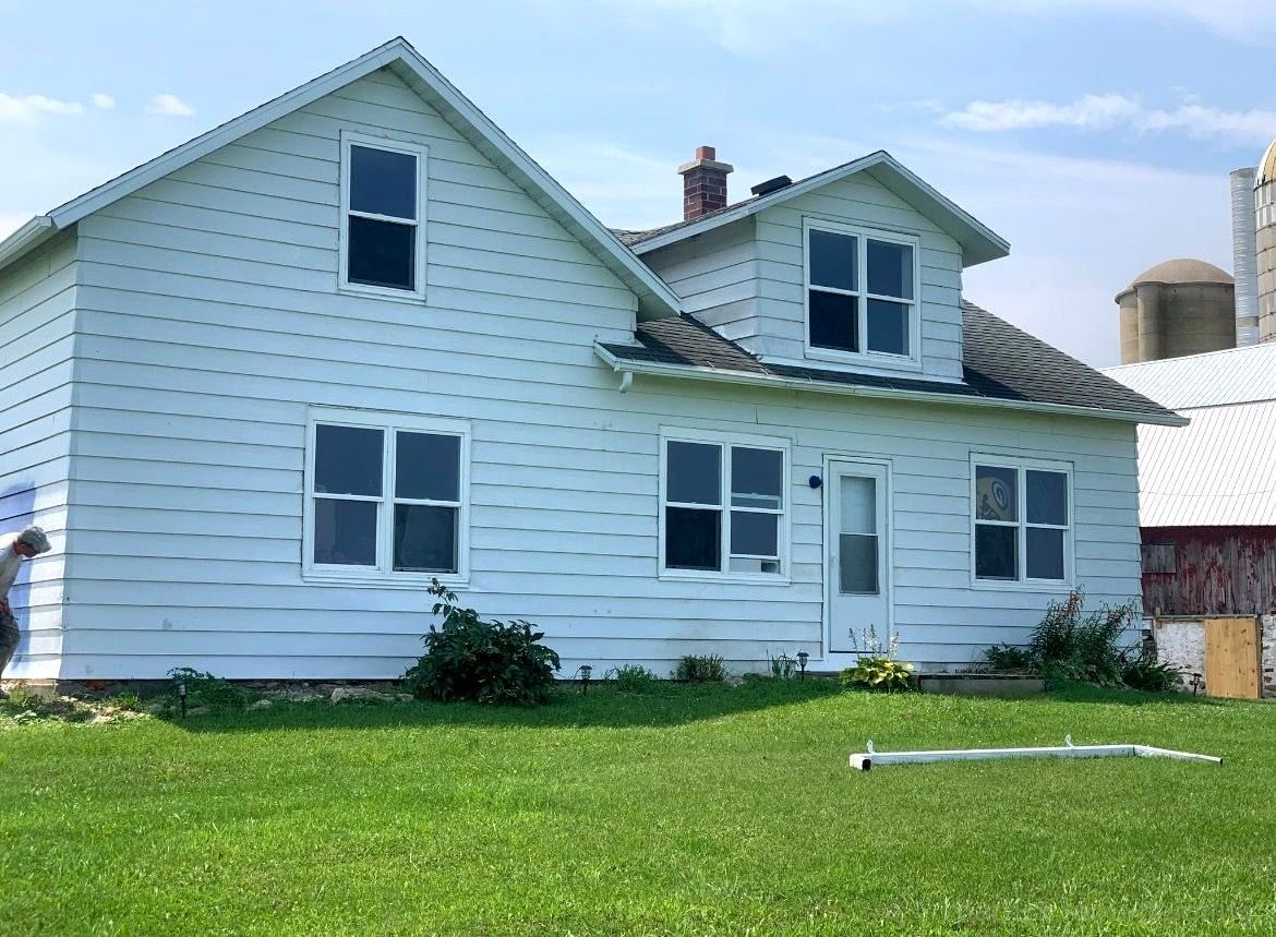 Barn painting services by Patrick Farm Painting in Boonville, New York. This image features a professionally restored barn or farmhouse surrounded by peaceful countryside scenery, open farmland, and natural outdoor lighting. The freshly painted siding, trim, and exterior surfaces highlight the craftsmanship of experienced barn painters and the trusted farm painting guy from Patrick Farm Painting, a company that paints barns in New York. The building appears clean, durable, and visually refreshed with smooth finishes and vibrant color restoration. This detailed description helps visually impaired website visitors imagine the rural setting, the scale of the agricultural structure, and the quality transformation completed during the farm painting project.