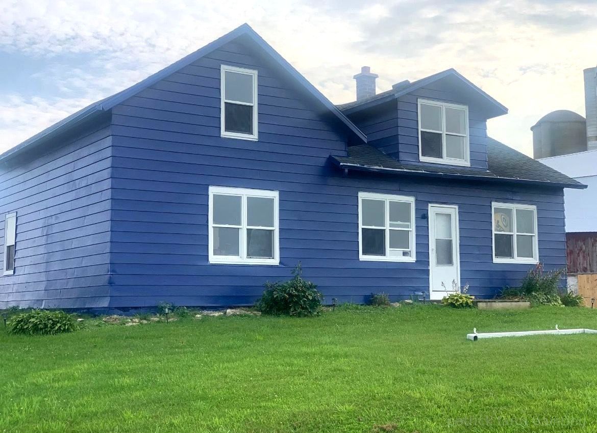 Barn painting services completed by Patrick Farm Painting in Ogdensburg, New York. This image shows a professionally restored barn or farmhouse surrounded by open countryside, farmland, and natural outdoor lighting. The freshly painted siding, trim, and exterior surfaces highlight the craftsmanship of experienced barn painters and the trusted farm painting guy from Patrick Farm Painting, a company that paints barns in New York. The structure appears clean, durable, and visually refreshed with smooth finishes and vibrant color restoration. This vivid description helps visually impaired website visitors imagine the peaceful rural setting, the scale of the agricultural building, and the dramatic transformation completed during the farm painting project.