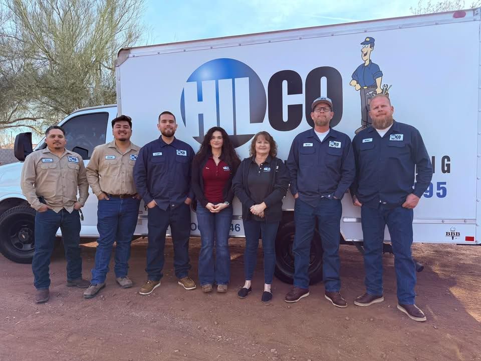 Person in work attire rings doorbell of ornate wooden door.
