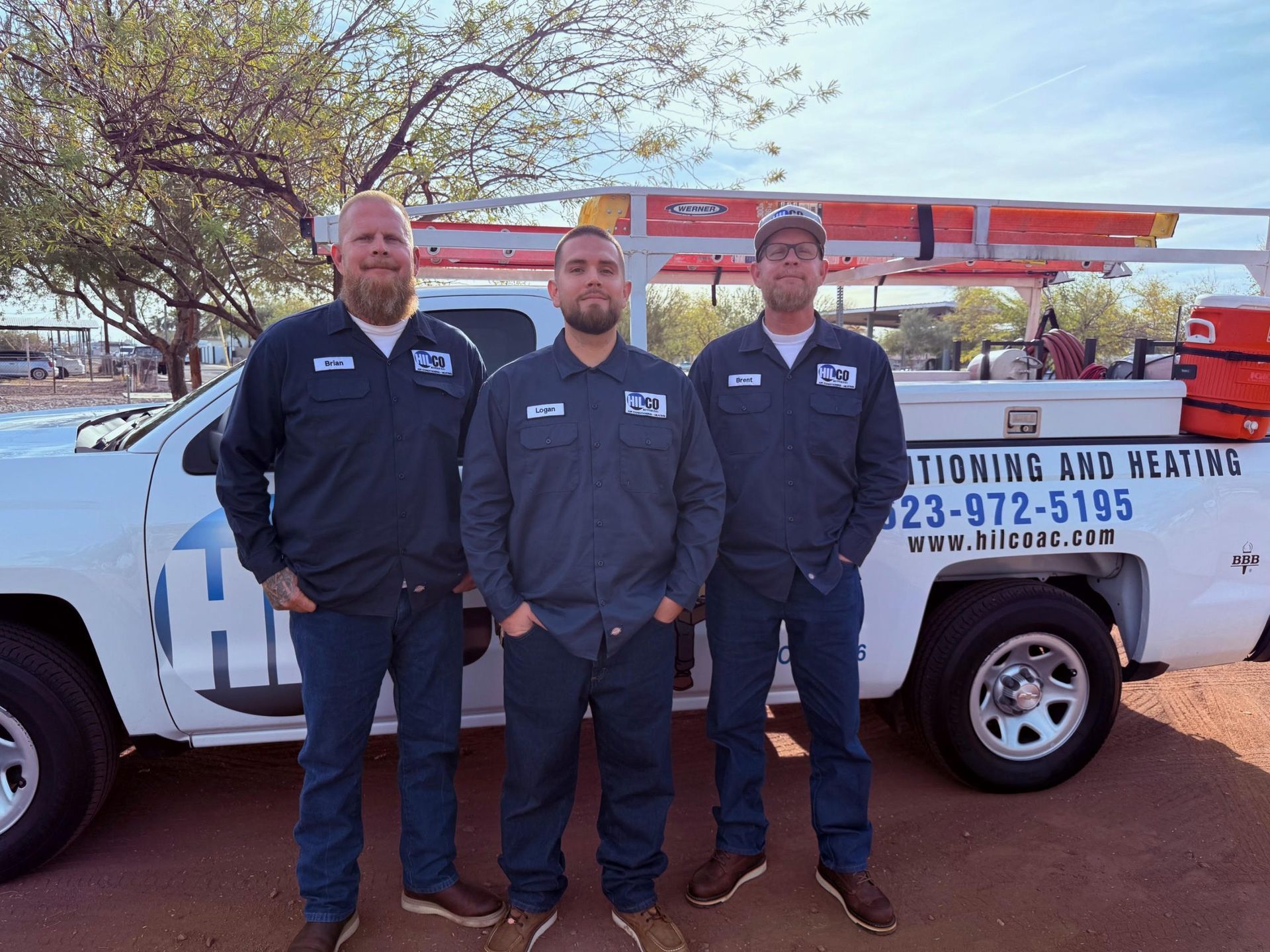 Couple shaking hands with service technician by van.