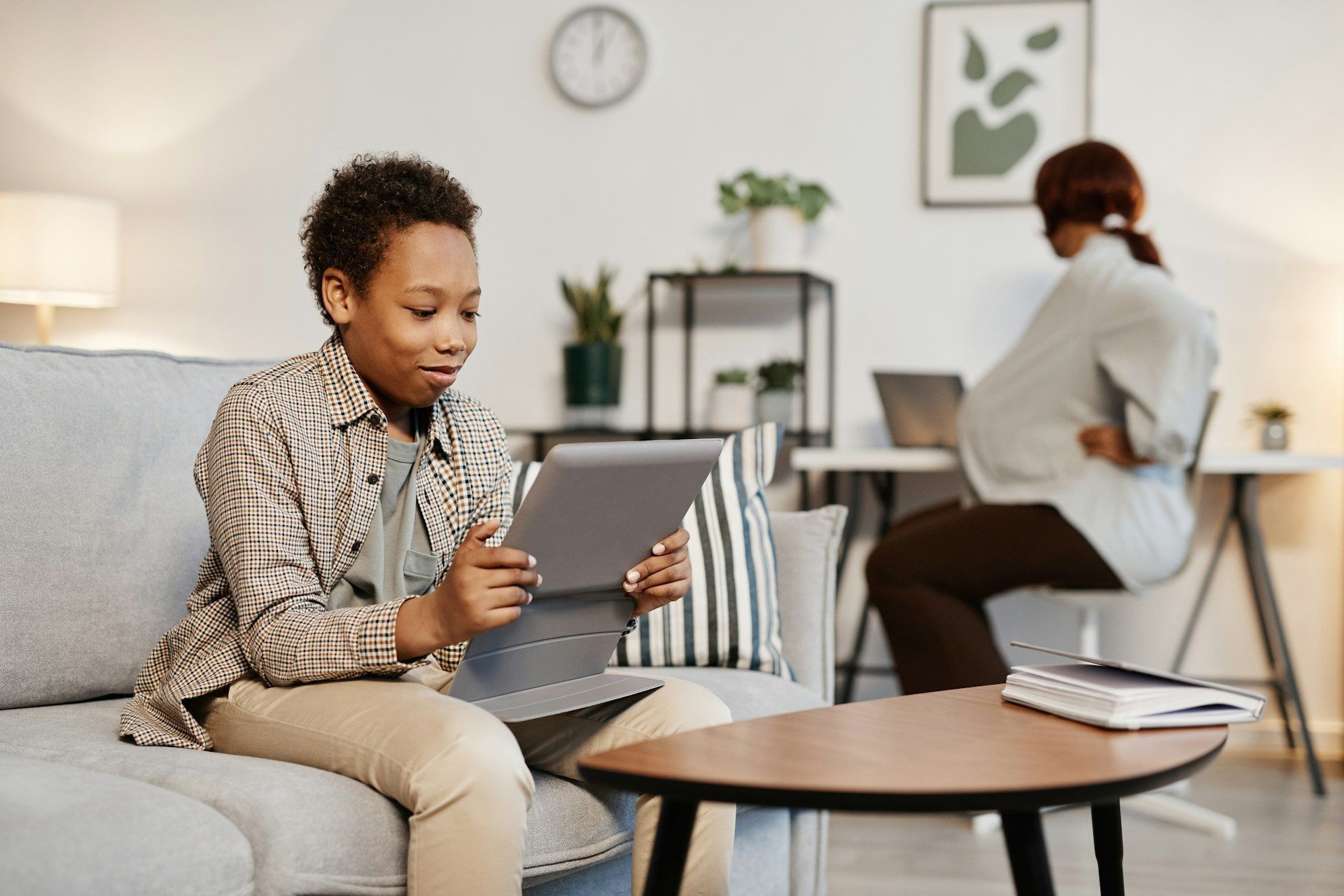 A technician wearing a mask working on a furnace in an attic.