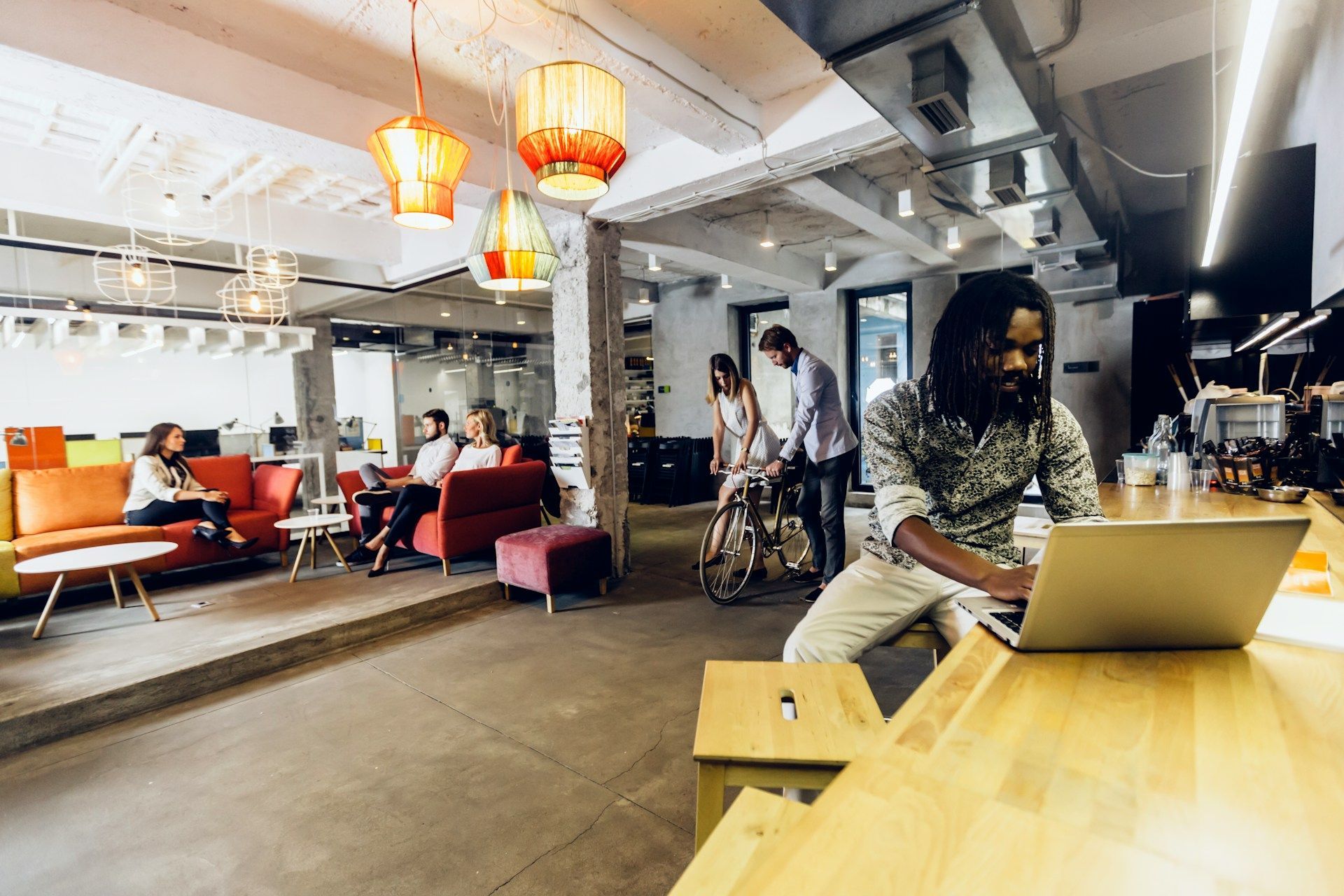 A technician wearing a mask working on a furnace in an attic.