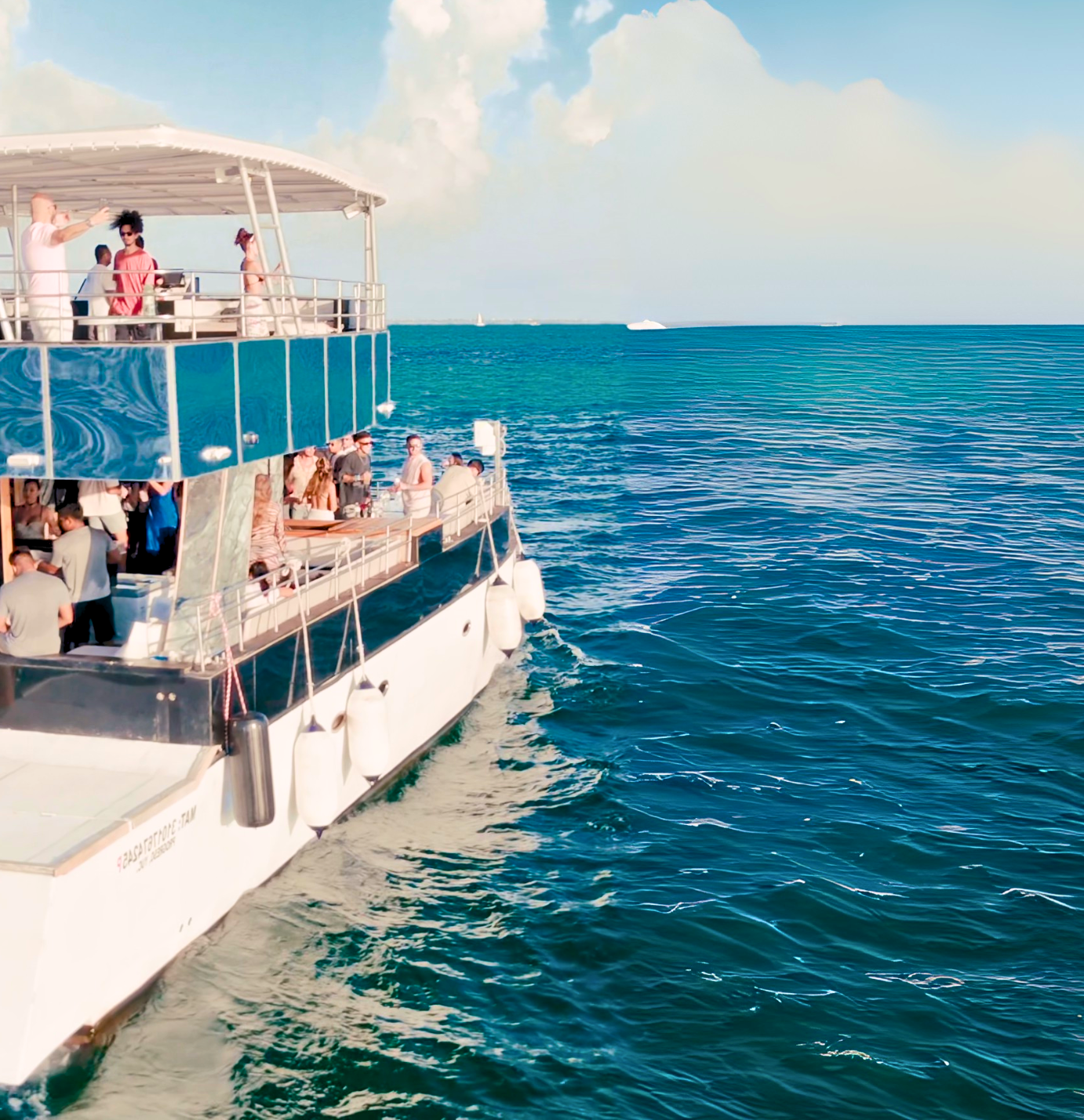 Un gran barco blanco con gente a bordo viaja por las aguas azules del océano bajo un cielo soleado. .Hix stage