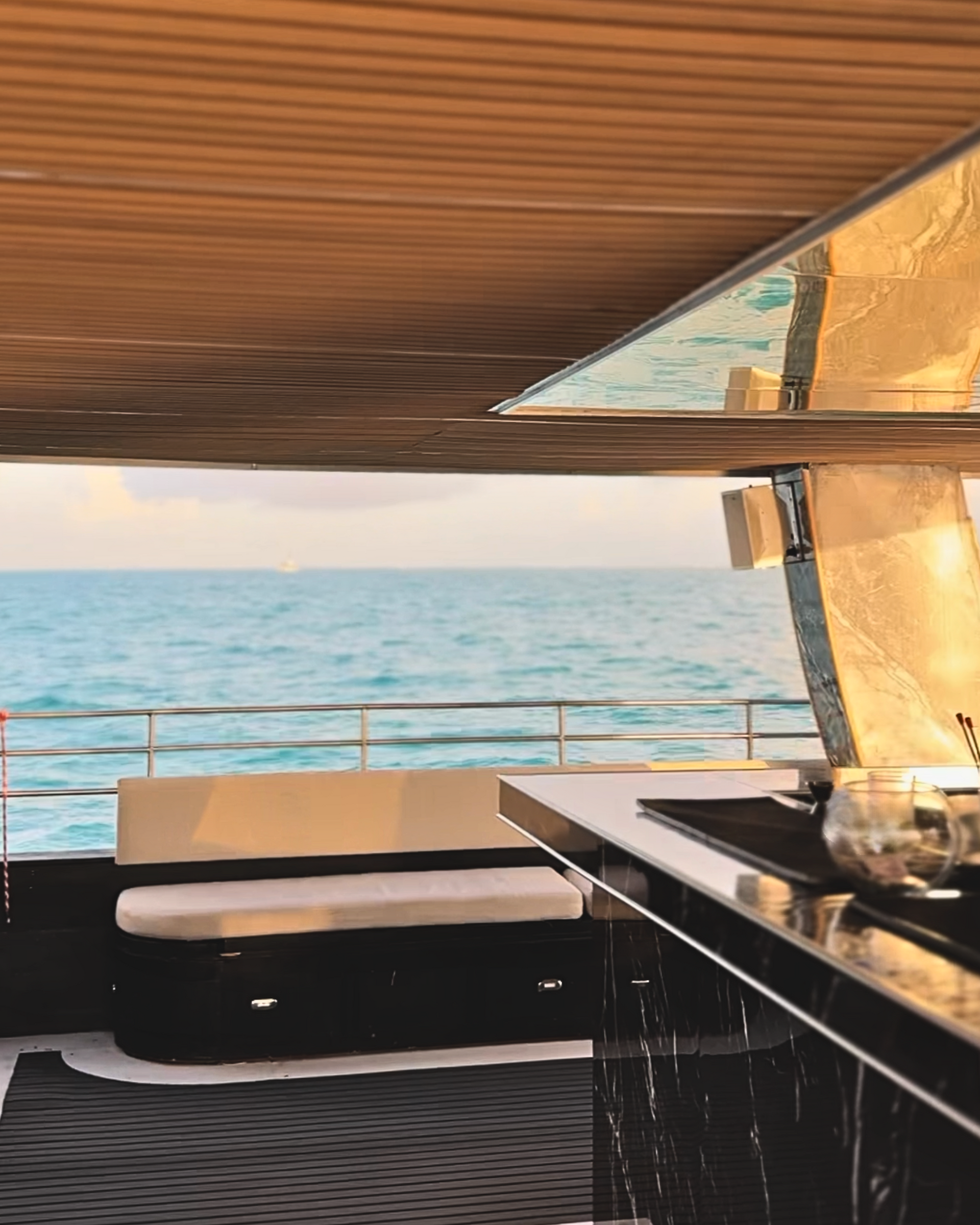 Cubierta de yate con barra incorporada, asientos y vista al mar.Hix stage