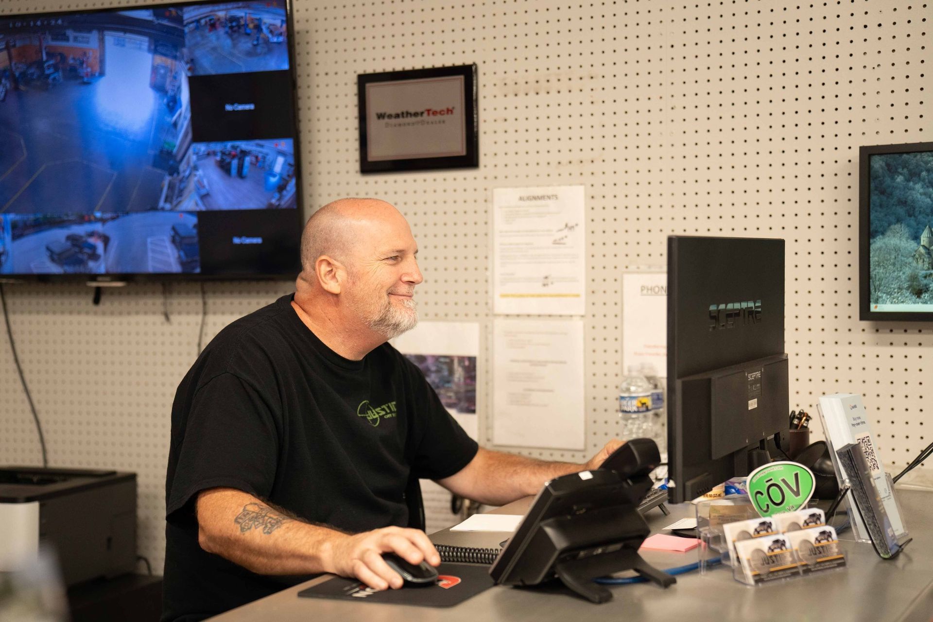 A Team Member in a Black T-Shirt Smiles While Sitting | Justice Off Road