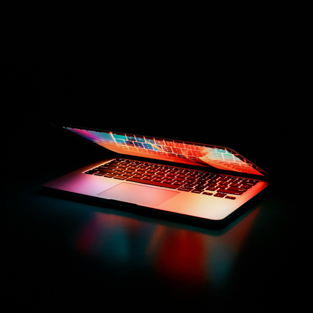 Laptop with an open screen, emitting colorful light because of filesharing