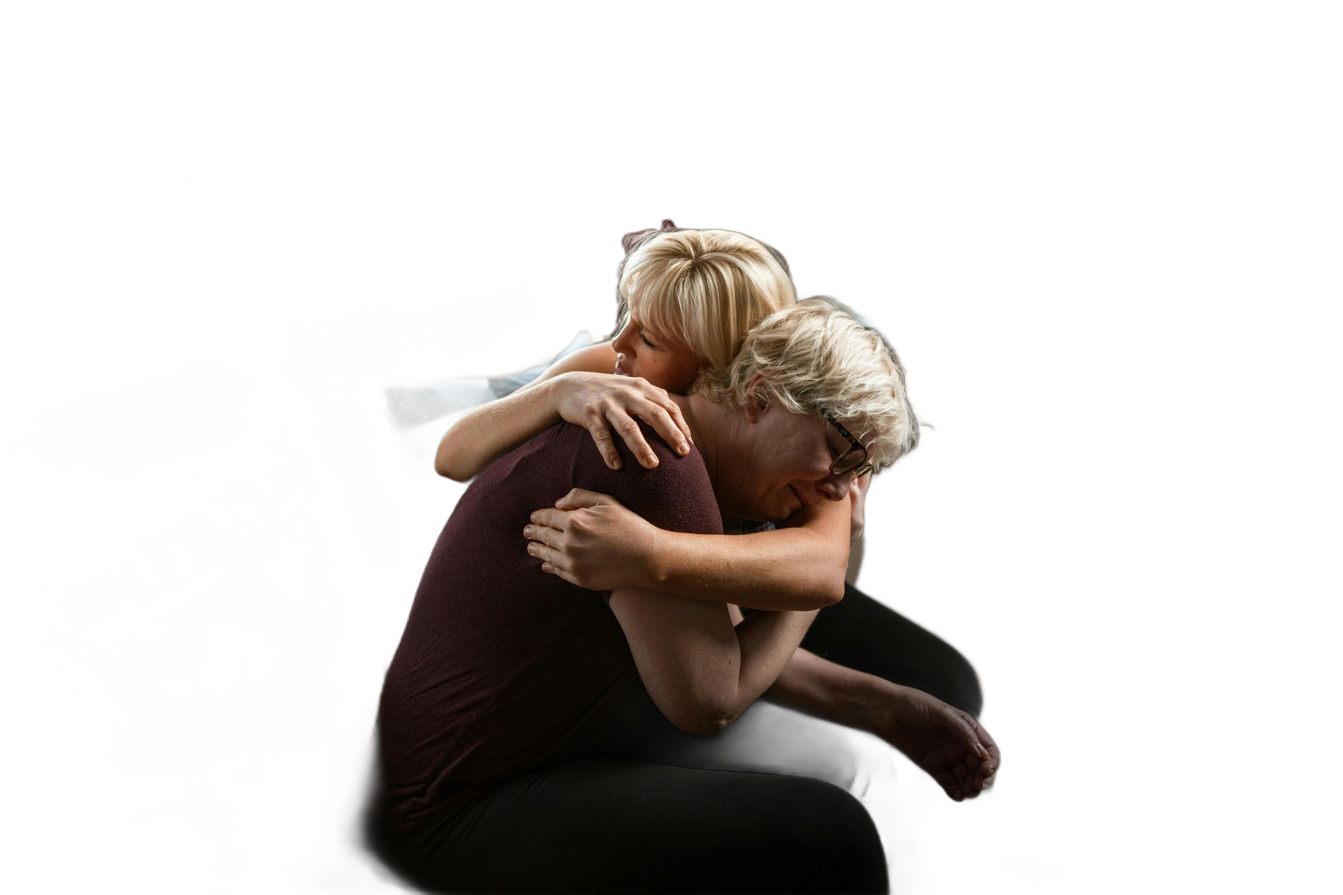 Two people embracing; one in burgundy shirt, one with blonde hair, white background.