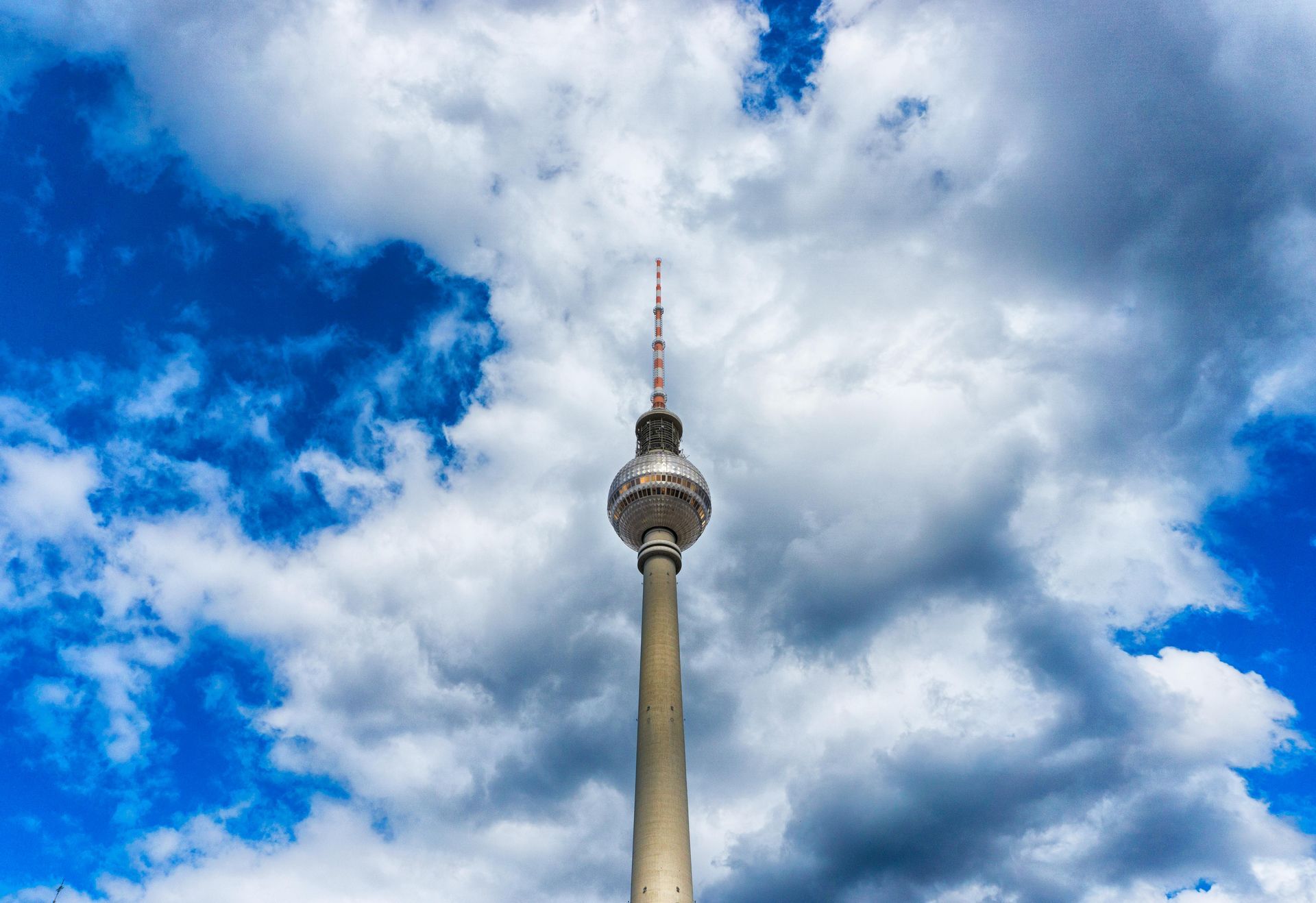 Fernsehturm vor blauem Himmel mit weißen Wolken. Himmel heißt auf Englisch sky.
