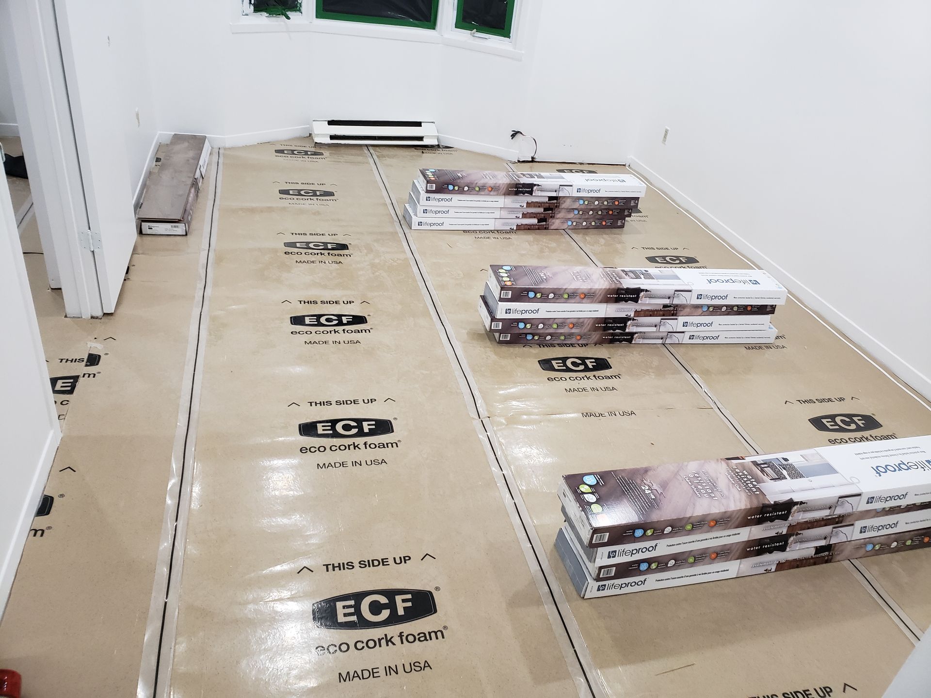 A room with a lot of cardboard boxes on the floor.