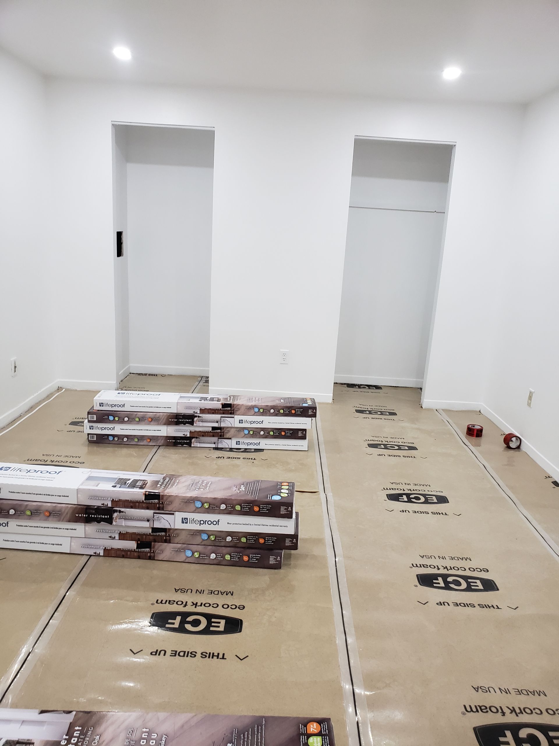 A room with a lot of boxes of flooring on the floor.