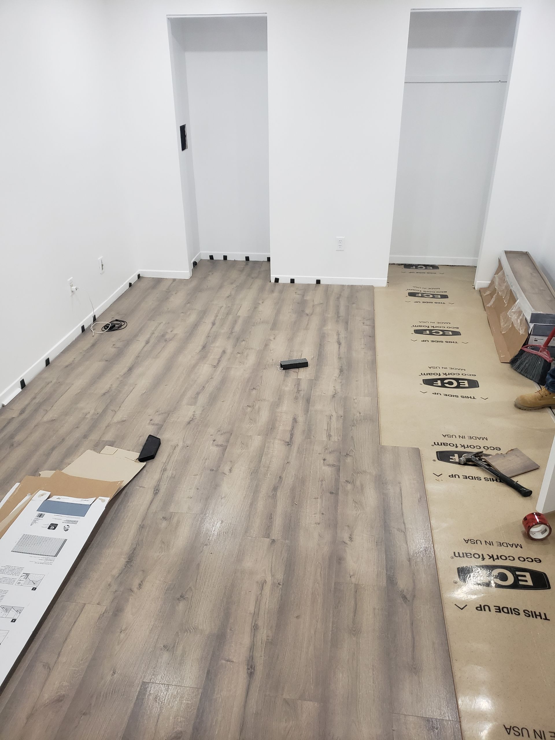 A room with a wooden floor and two doors.