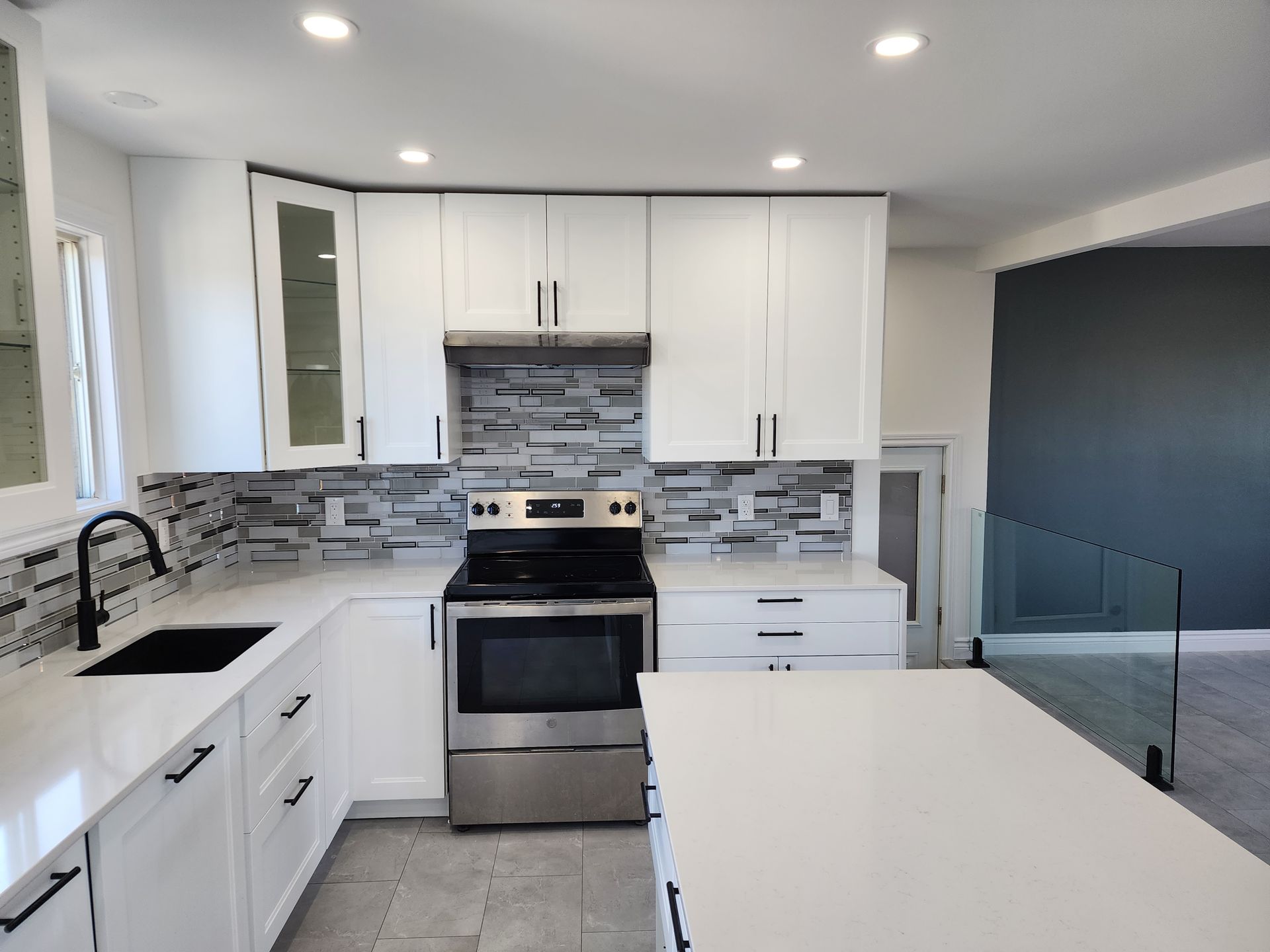 A kitchen with white cabinets and stainless steel appliances