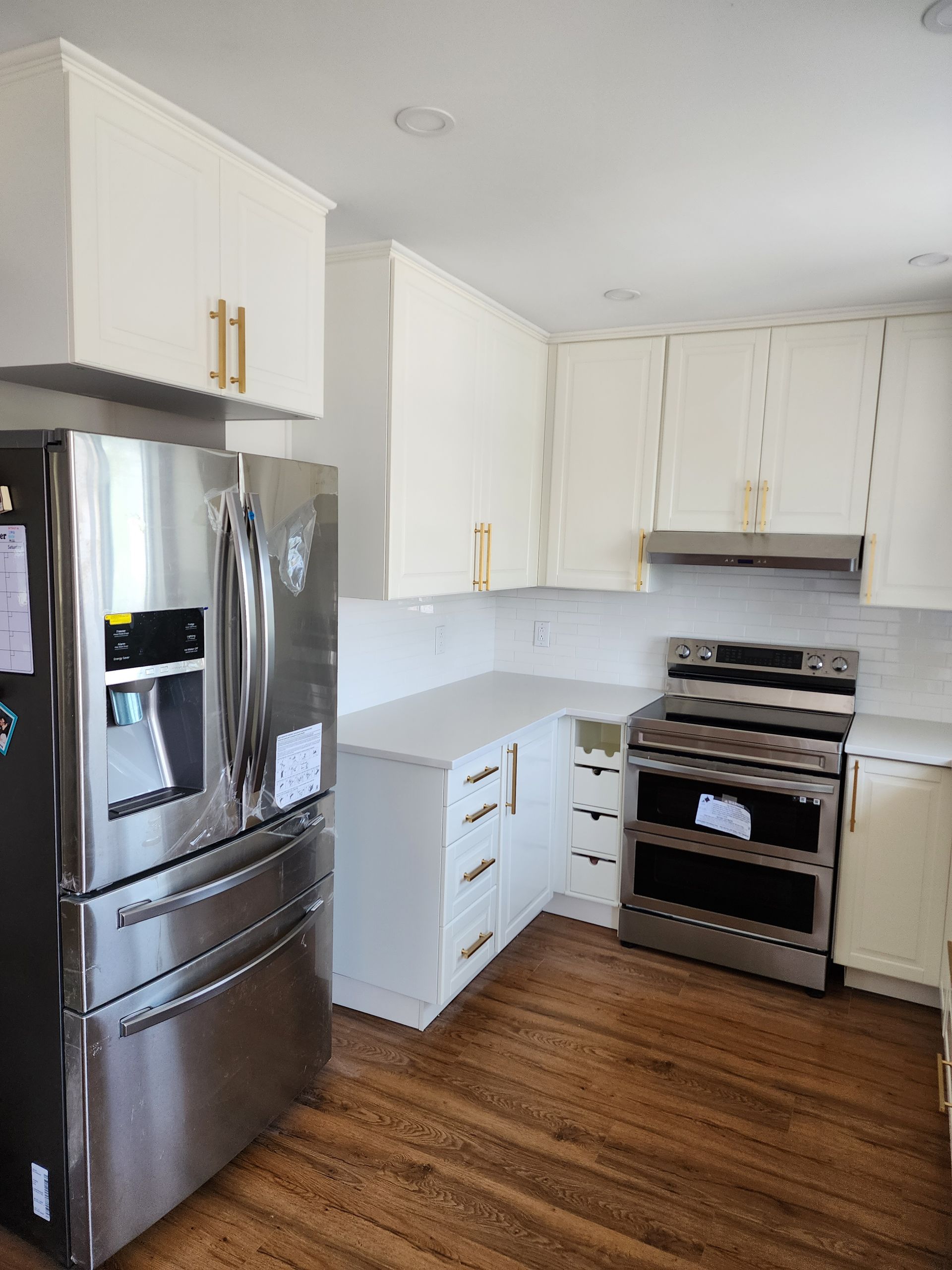 A kitchen with stainless steel appliances and white cabinets.