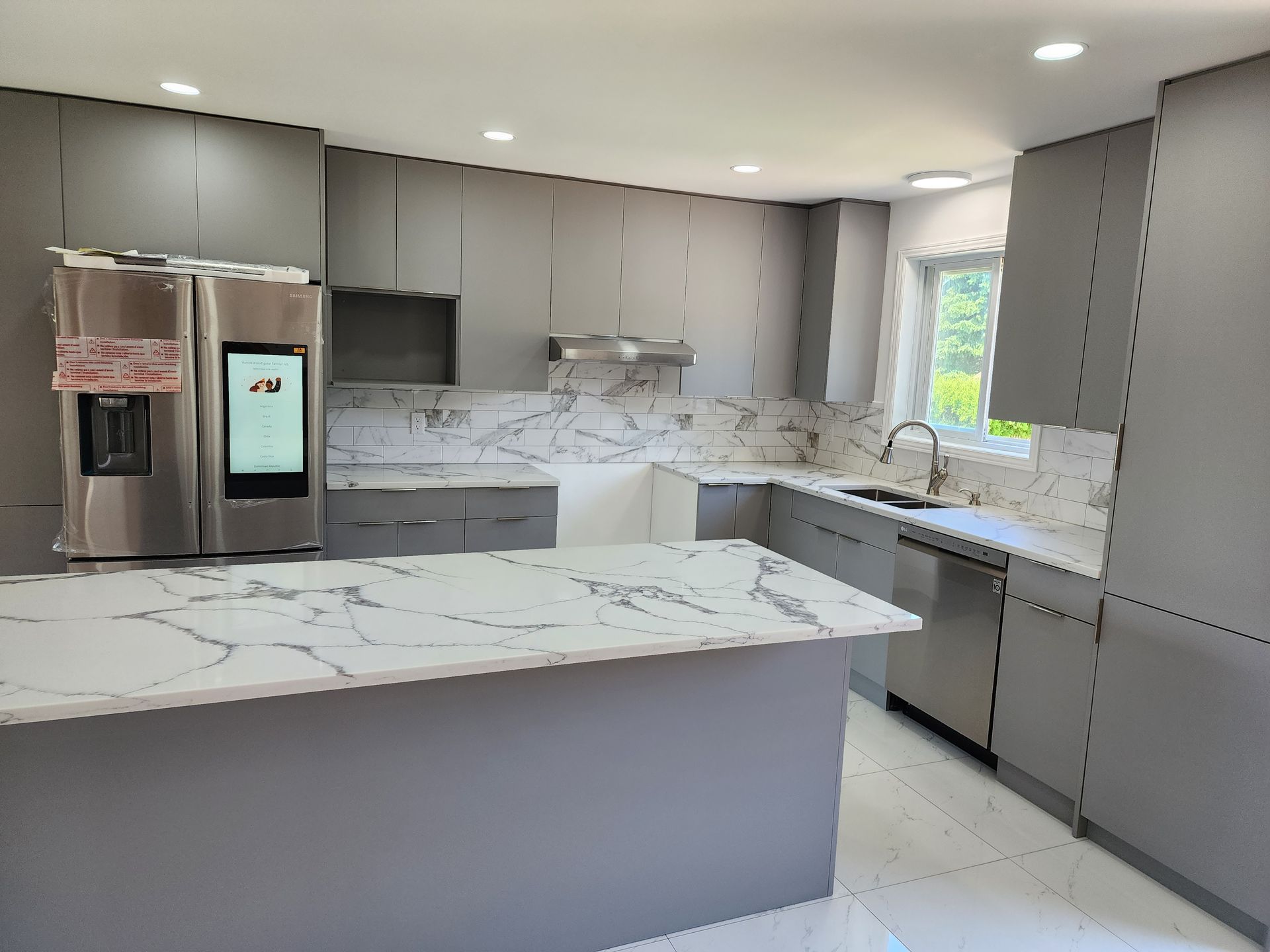 A kitchen with stainless steel appliances and marble counter tops.