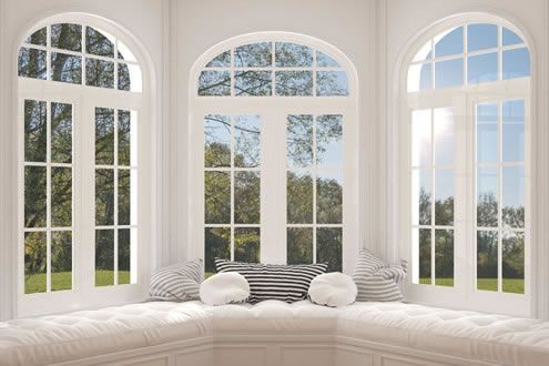 A living room with three arched windows and a couch.