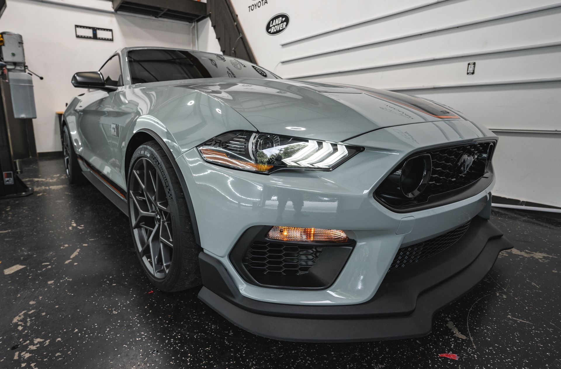 A gray mustang is parked in a garage.