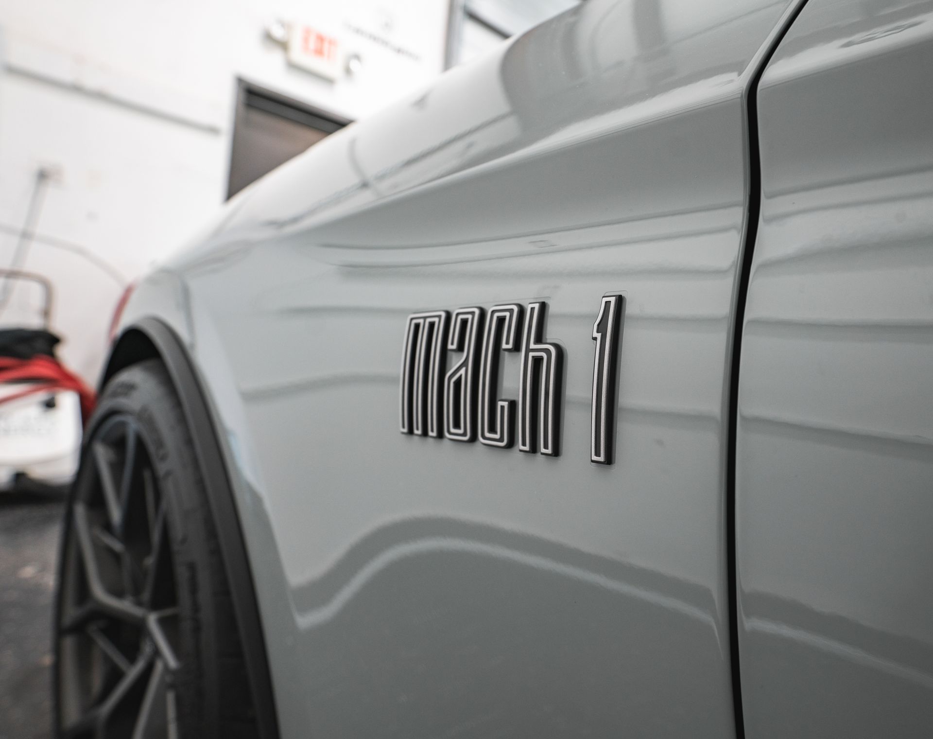 A close up of the side of a white ford mustang mach 1