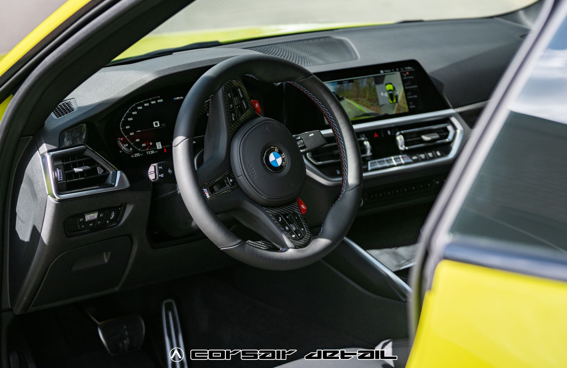 The interior of a yellow bmw with a steering wheel
