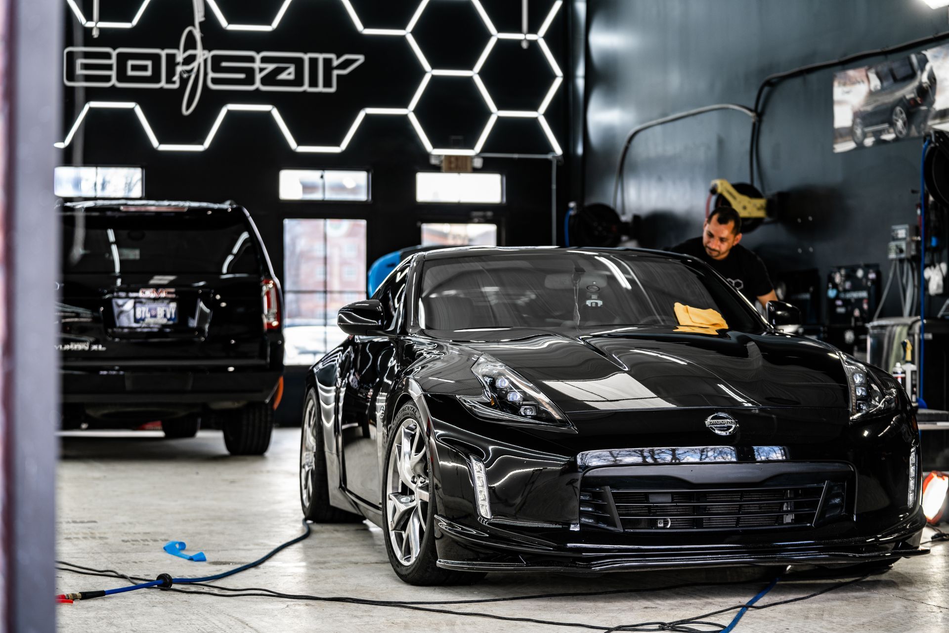 A black sports car is being worked on in a garage.