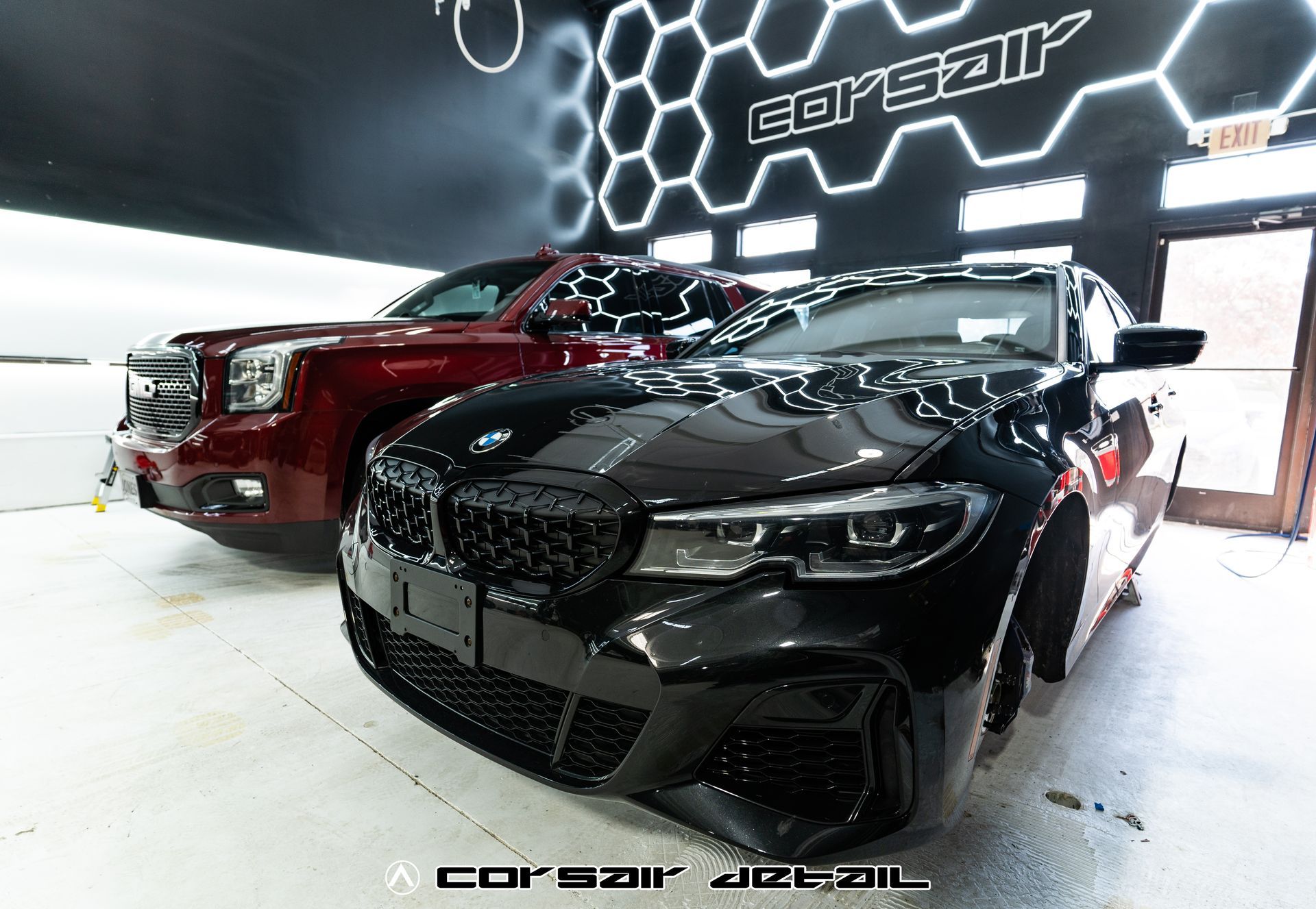 Two cars are parked next to each other in a garage.