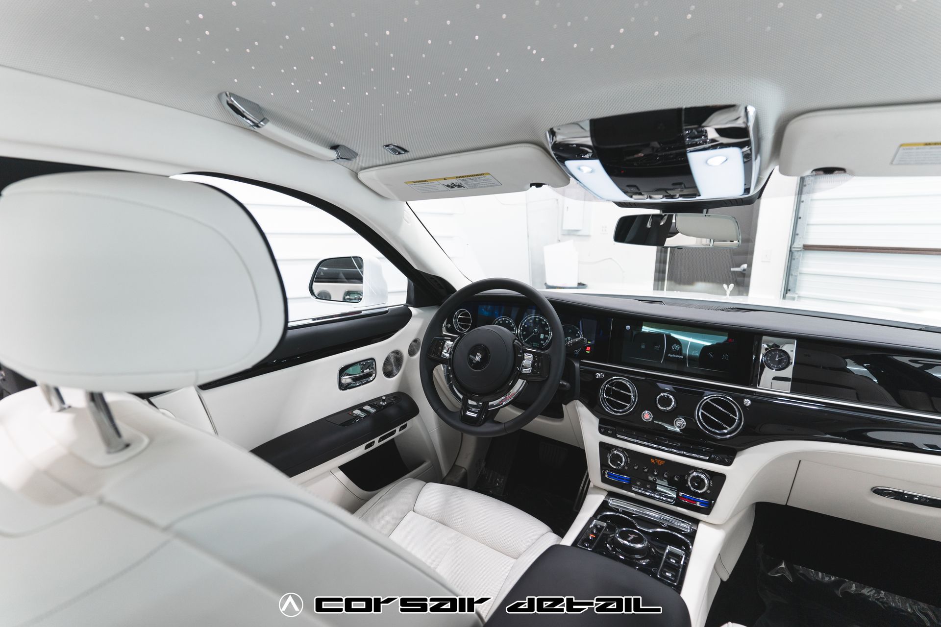 The interior of a white rolls royce ghost car