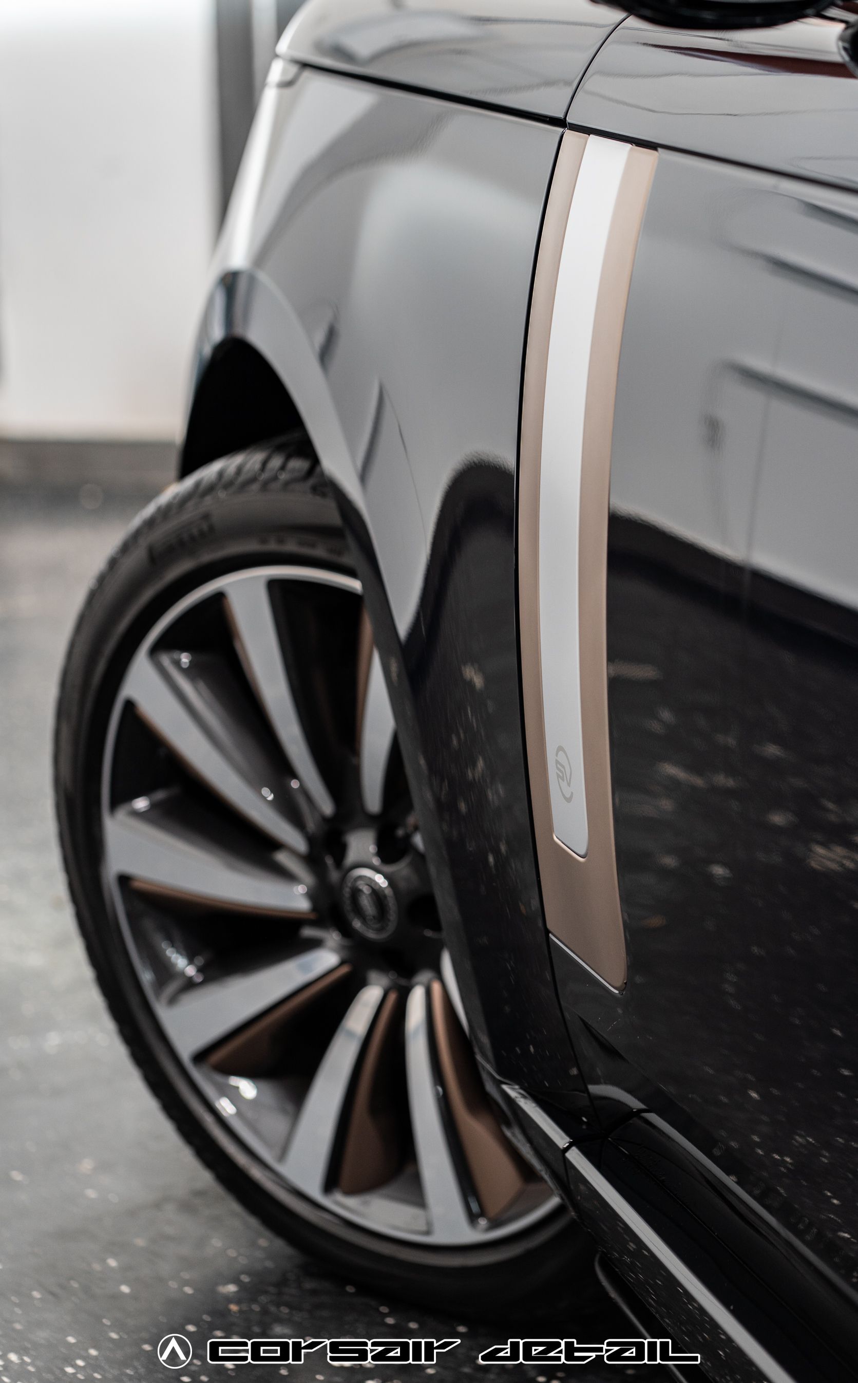 A black car with a white stripe on the side is parked in a garage.