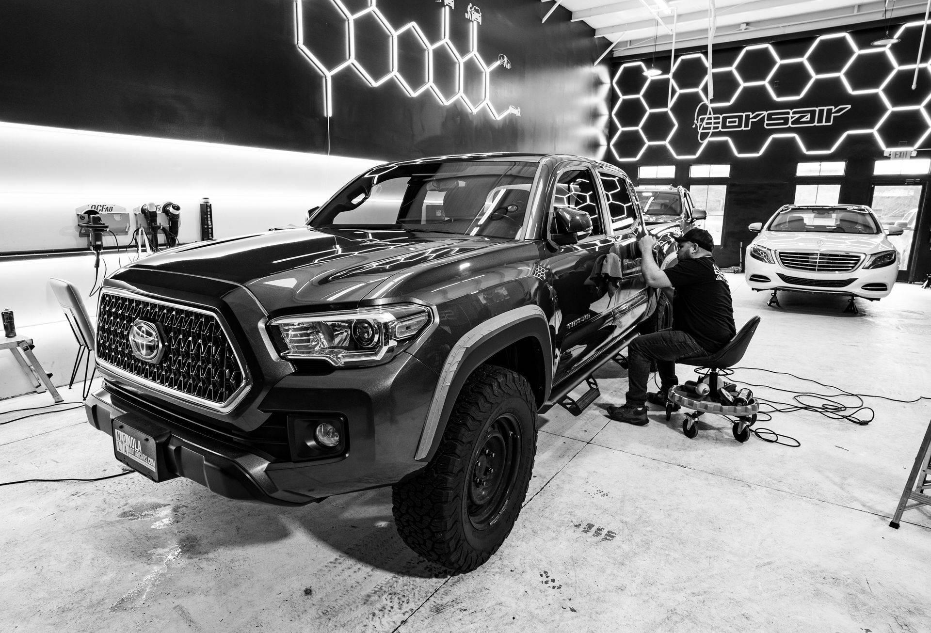 A black and white photo of a truck in a garage.