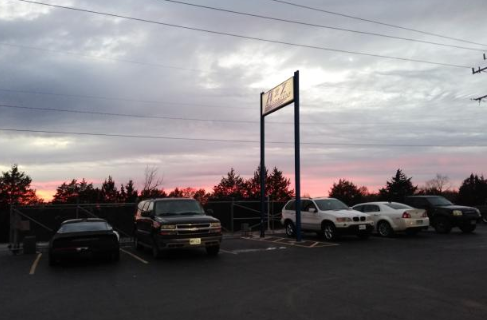A row of cars are parked in a parking lot at sunset. | A2Z AutosLLC