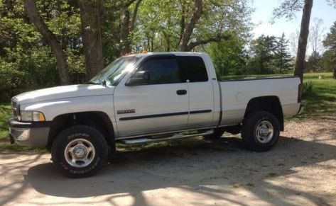 A white truck is parked in a gravel lot. | A2Z AutosLLC