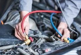 A man is working on the air conditioning system of a car. | A2Z AutosLLC