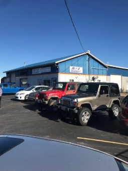 A row of cars are parked in front of a building. | A2Z AutosLLC