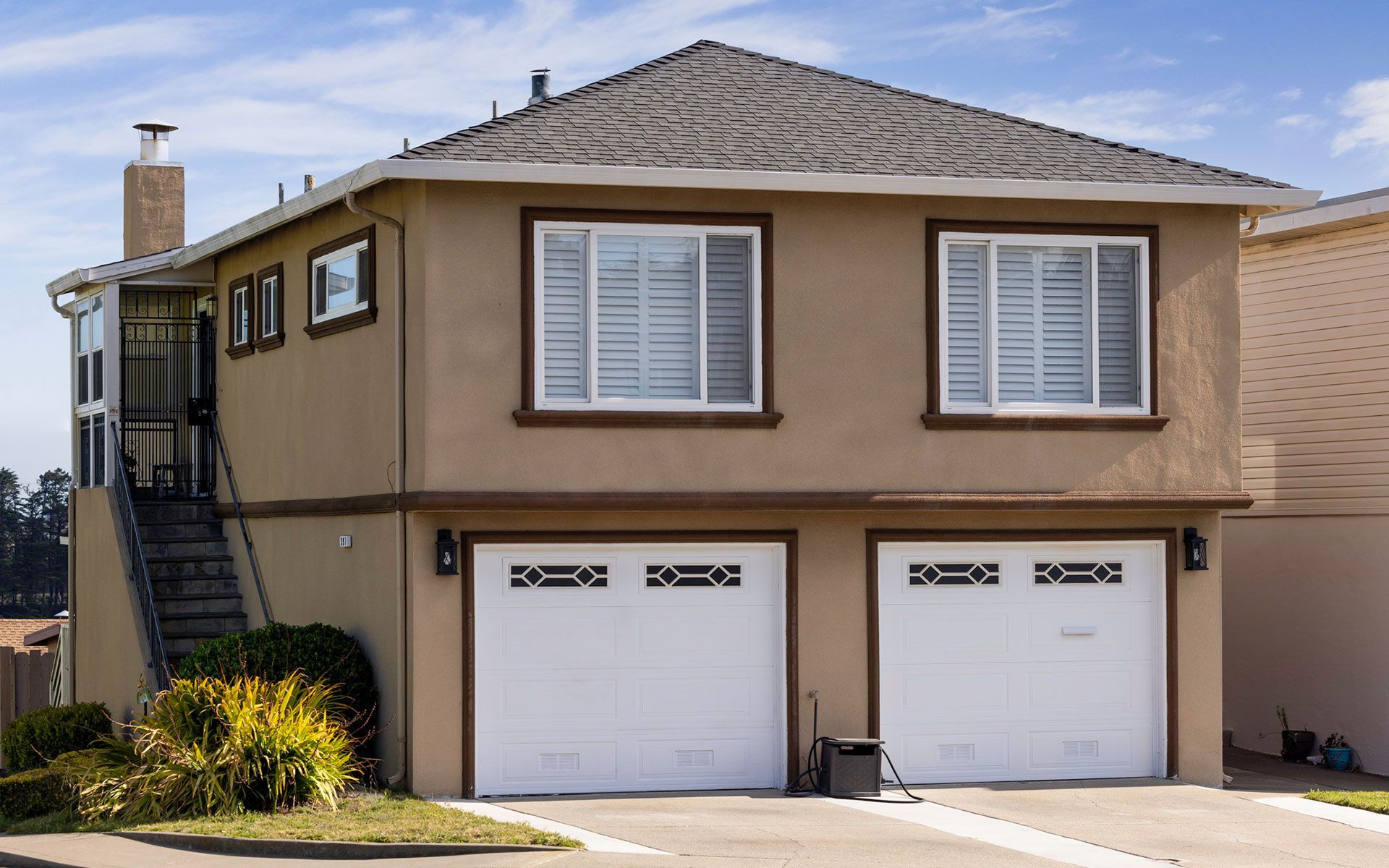 A house with two garage doors and two windows