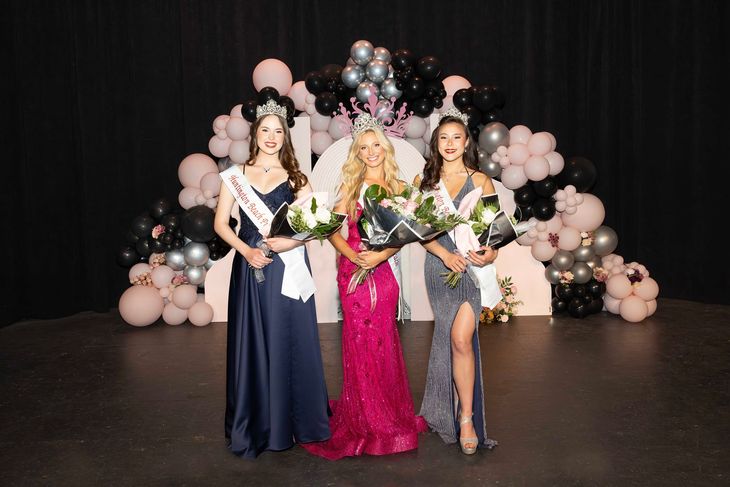 Three women are standing next to each other on a stage holding flowers.
Princess Laurel Brookhyser (left) , Queen Nicole Vogt (center), Princess Catherine Dozier (right). 