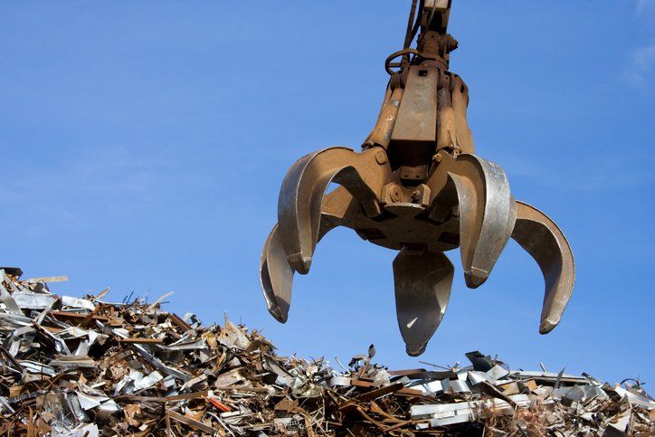 a crane is reaching into a pile of scrap metal .