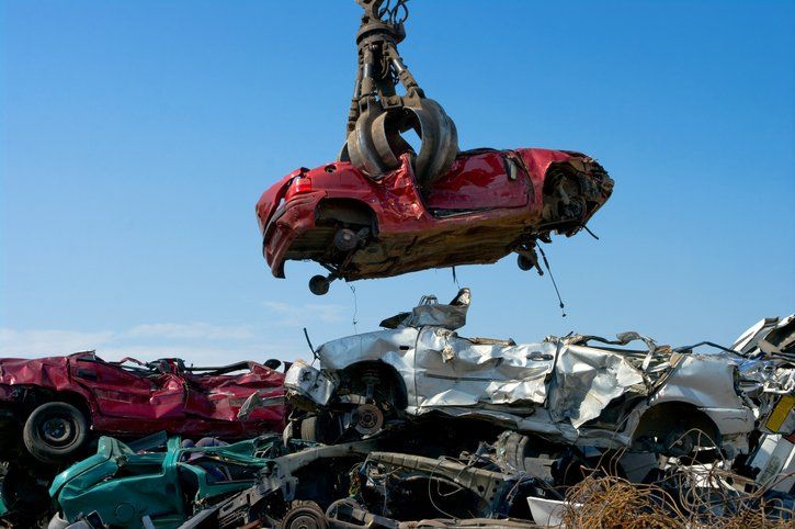 a red car is being lifted into the air by a crane .