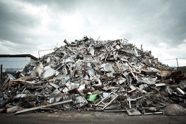 a large pile of scrap metal is sitting on the ground .