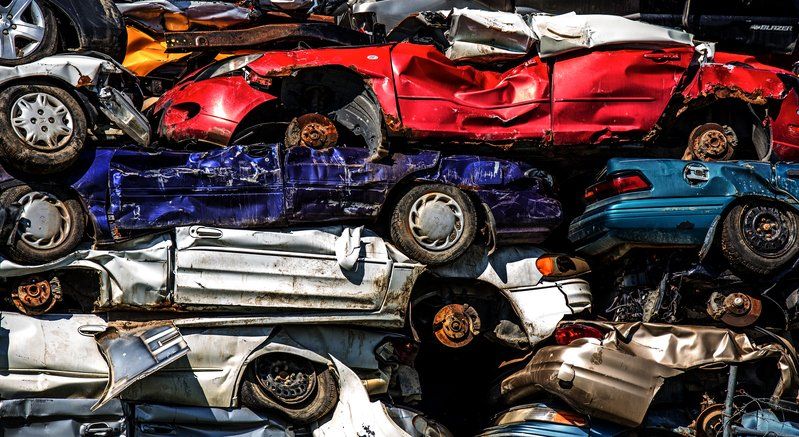 a pile of wrecked cars stacked on top of each other .