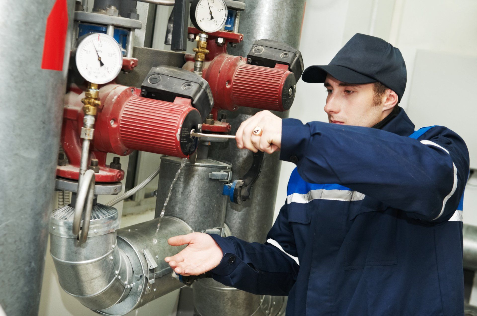 Repairman Working On Water Pump In Boiler Room — Somers Point, NJ — McBride & Company Plumbing, Heating, Air Conditioning