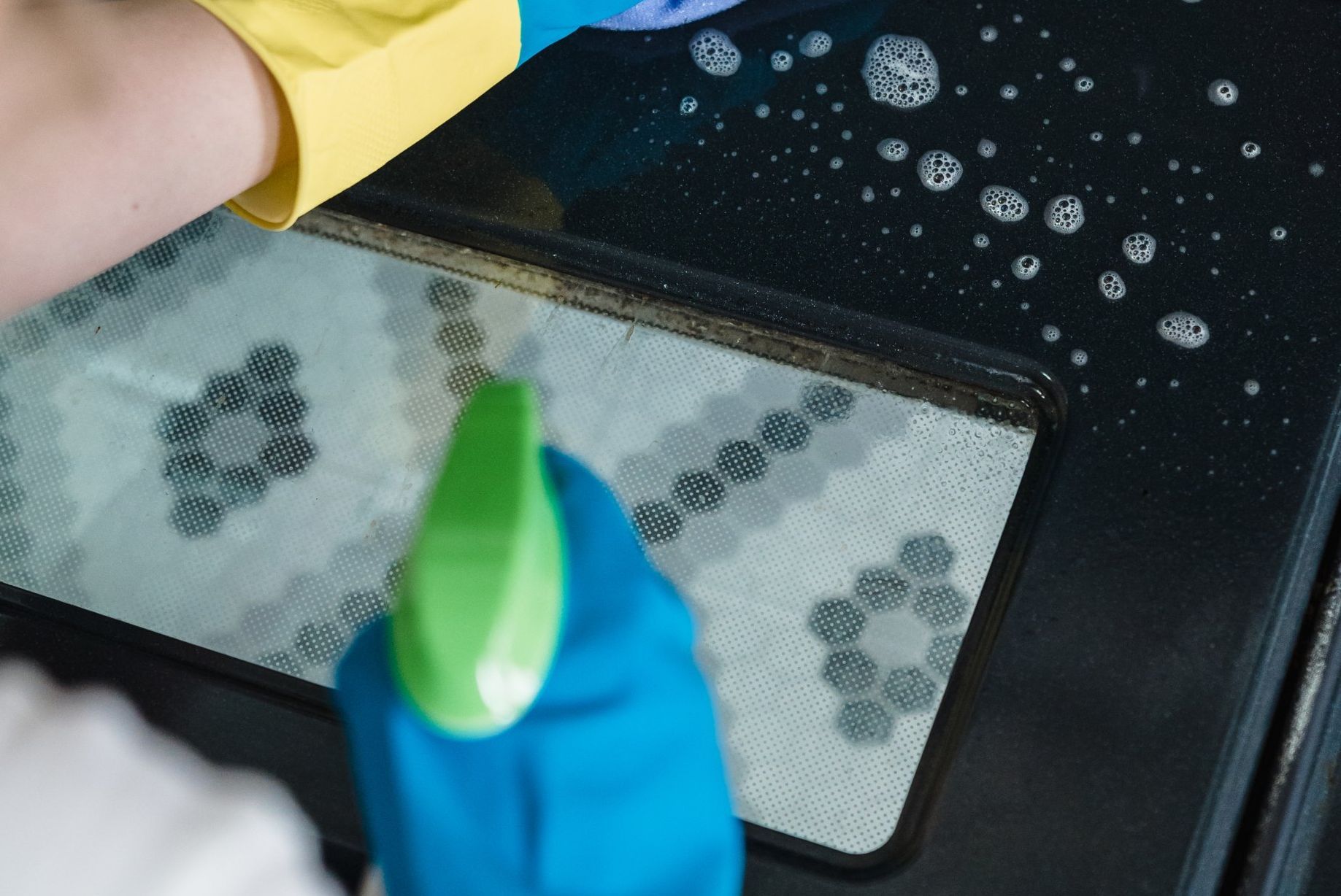 A person cleaning an oven